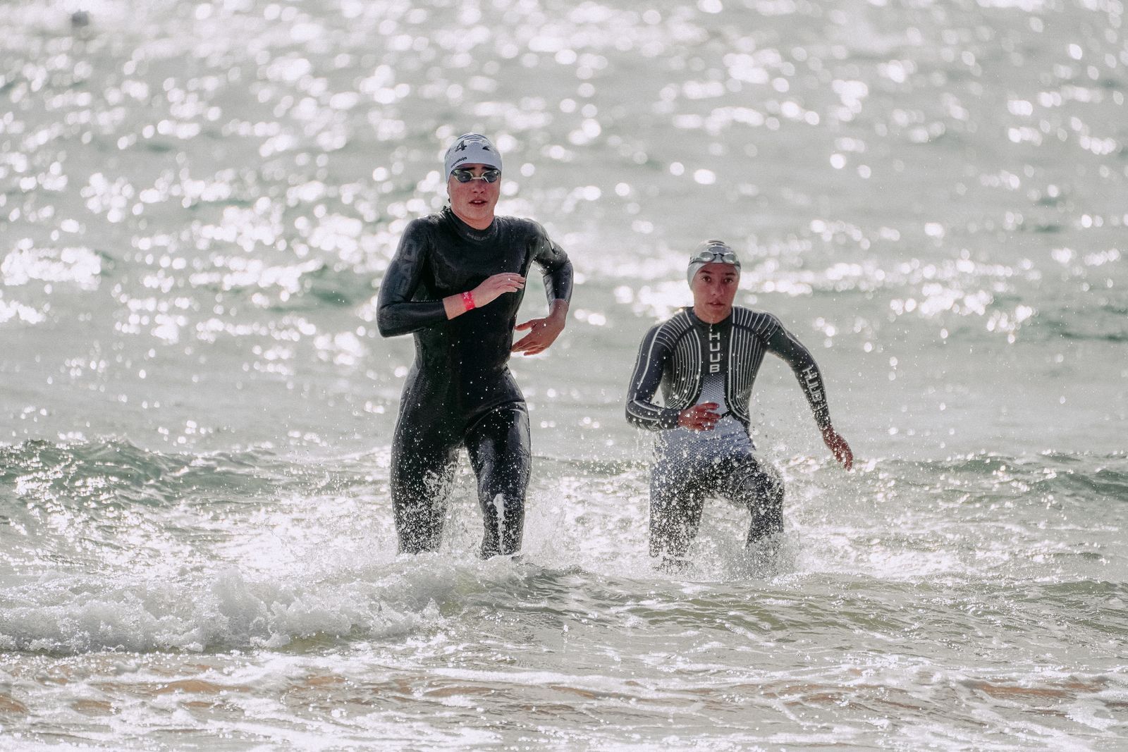 Deux triathlètes en combinaison sortant de l'eau au début d'une course