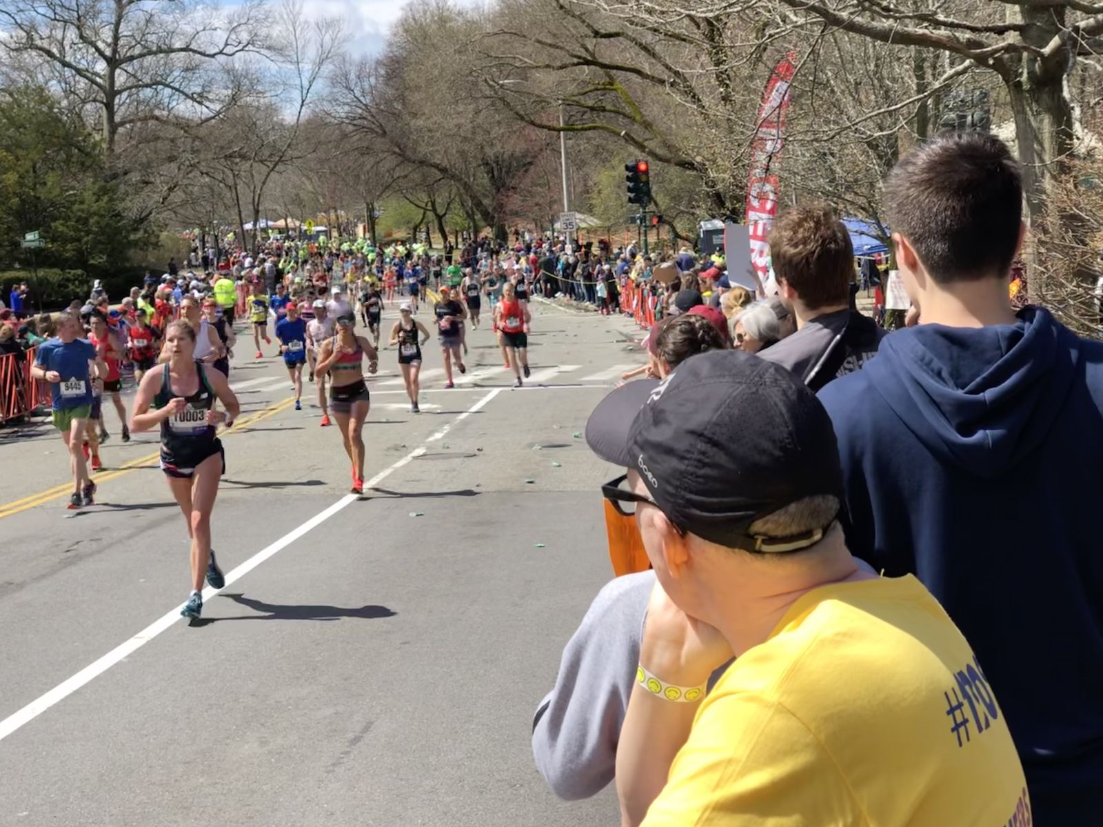 Peloton de marathoniens sur une avenue arborée au printemps