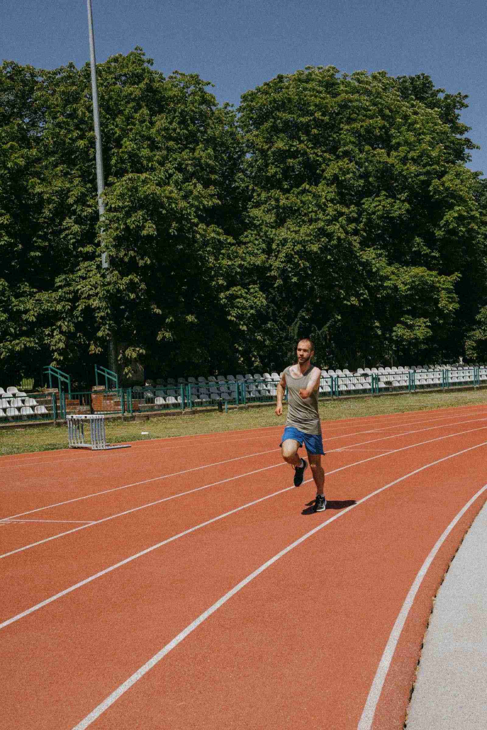 Coureur à l'entraînement sur une piste entourée de verdure