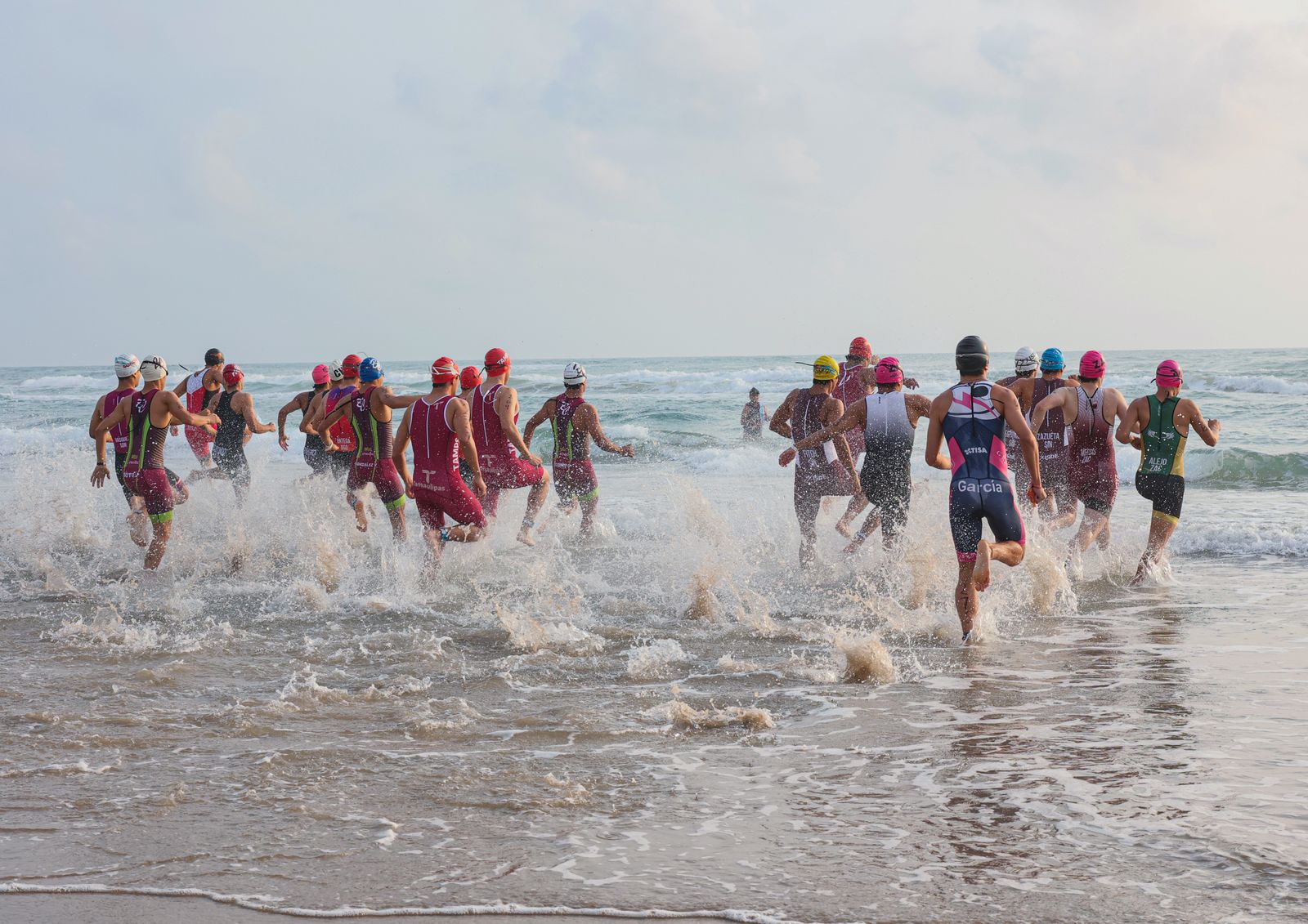 Nageurs en combinaison lors d'un départ de triathlon en eau libre