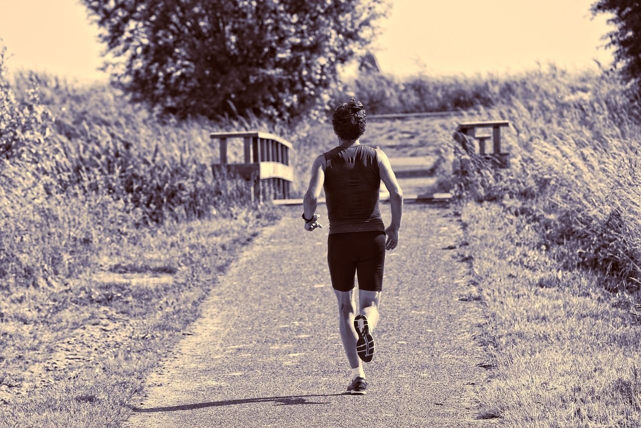 Coureur à l'entraînement sur un chemin bordé d'herbe