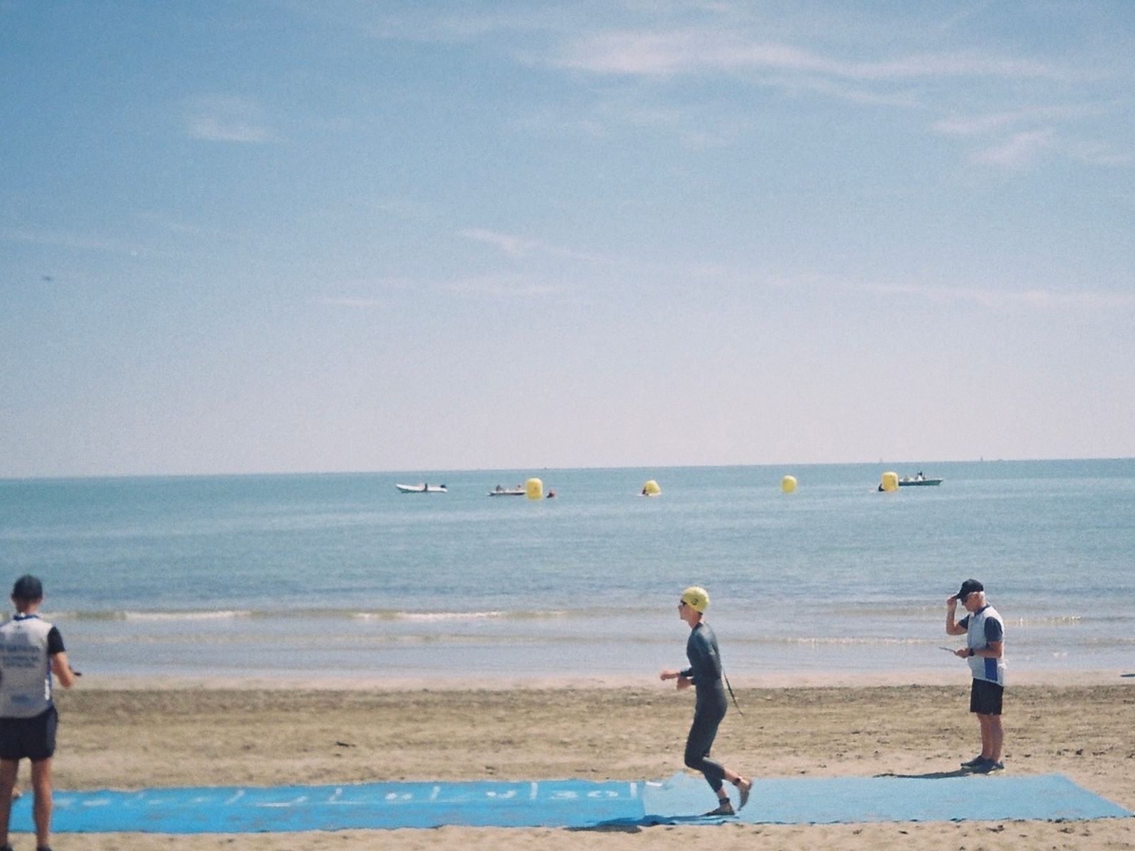 Athlètes courant sur une plage lors d'un triathlon en bord d'océan