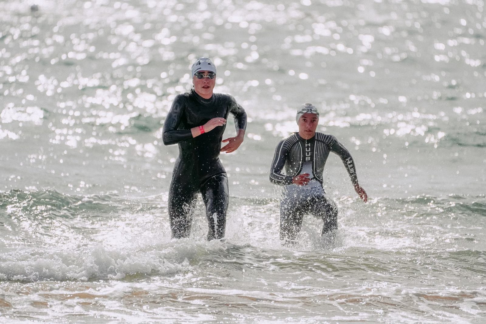 Triathlètes en combinaison sortant de l'eau au sprint