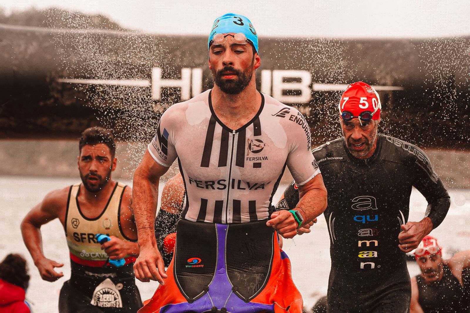 Triathlètes courant dans l'eau au départ d'une épreuve