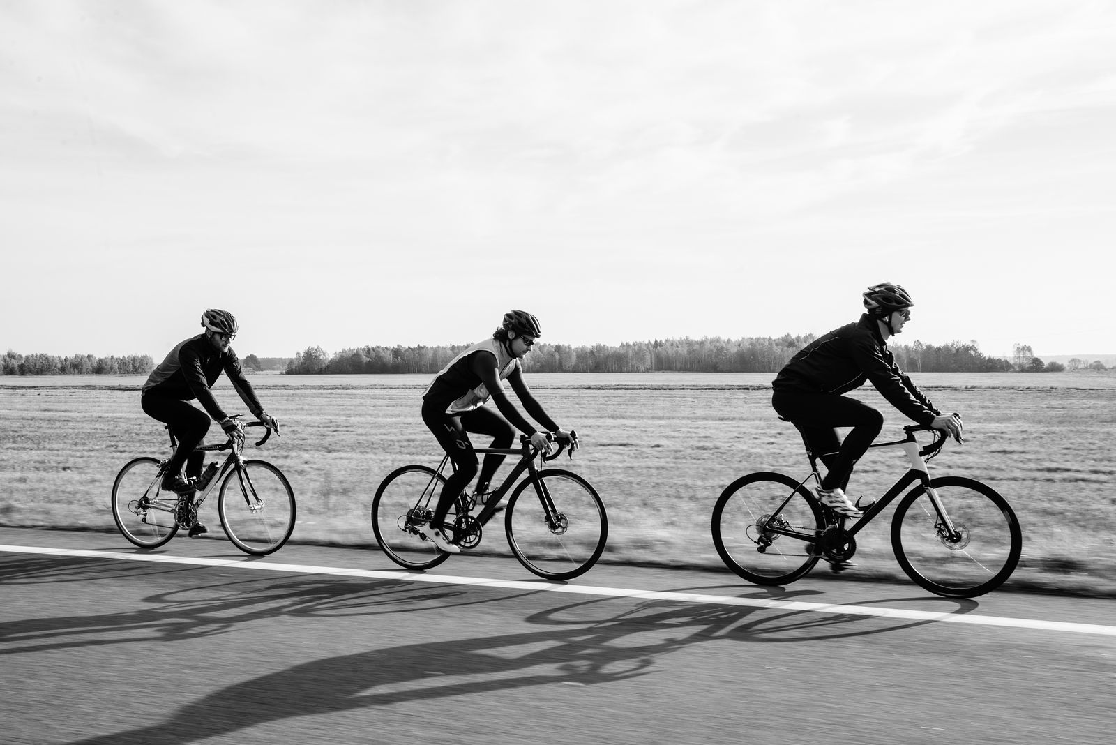 Trois cyclistes en file sur une route de campagne à l'entraînement