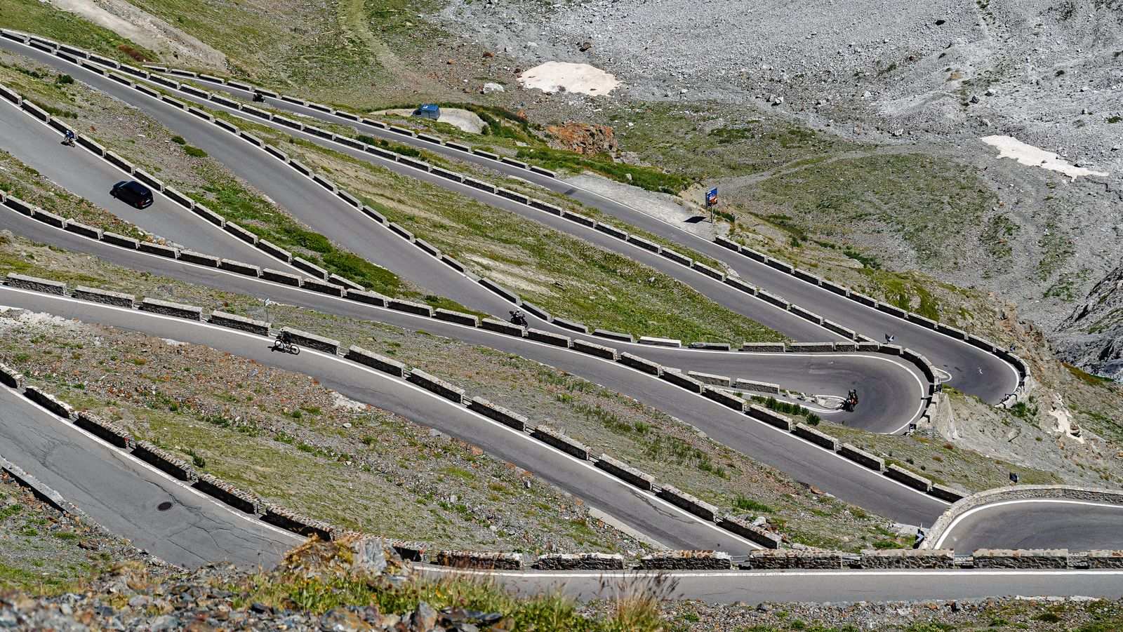 Vue aérienne d'une route de montagne en lacets parcourue par des cyclistes